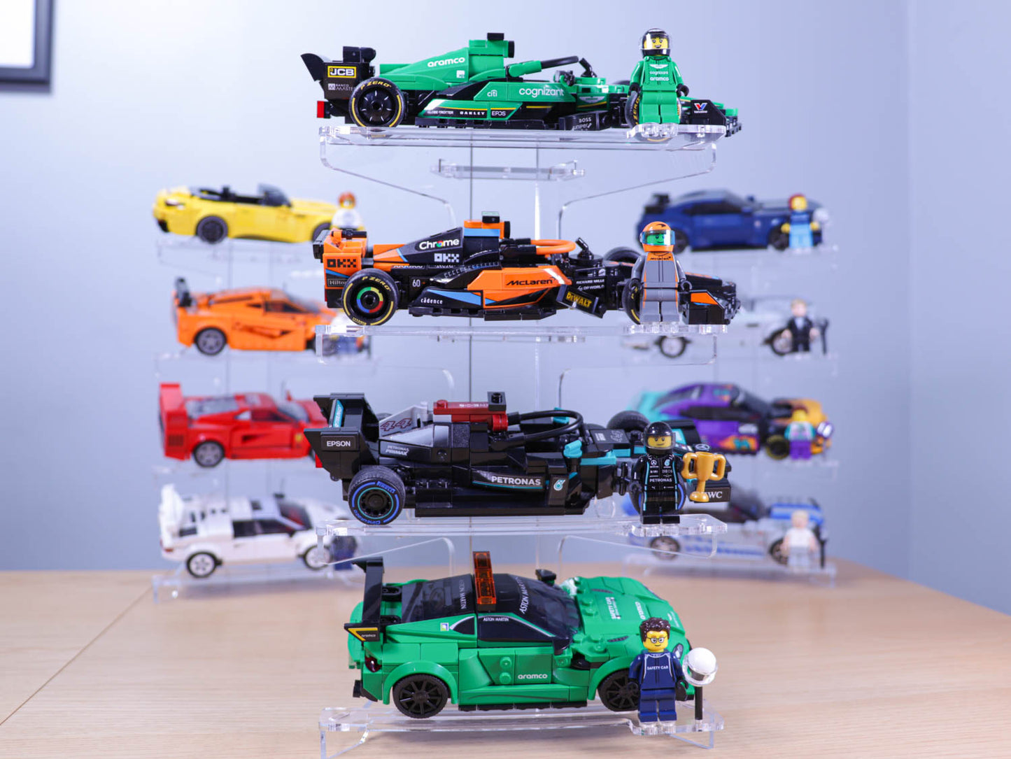 Three Brix Plus acrylic display stands lined up on a shelf, each holding four LEGO® Speed Champions cars